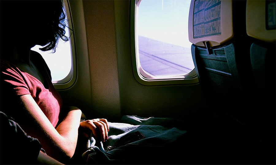 girl looks outside airplane window